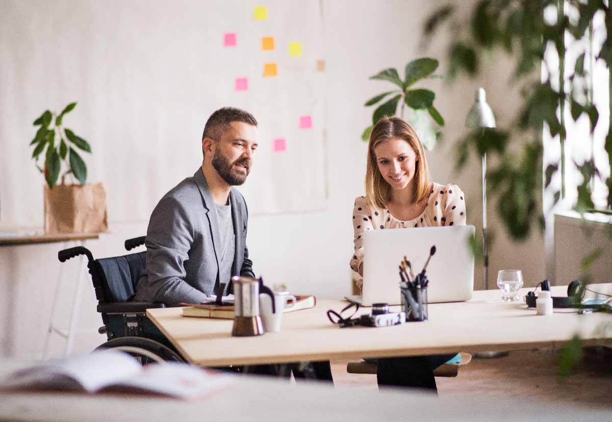 Two Business People With Wheelchair In The Office Peqyvcu.jpg - JRN Contábil